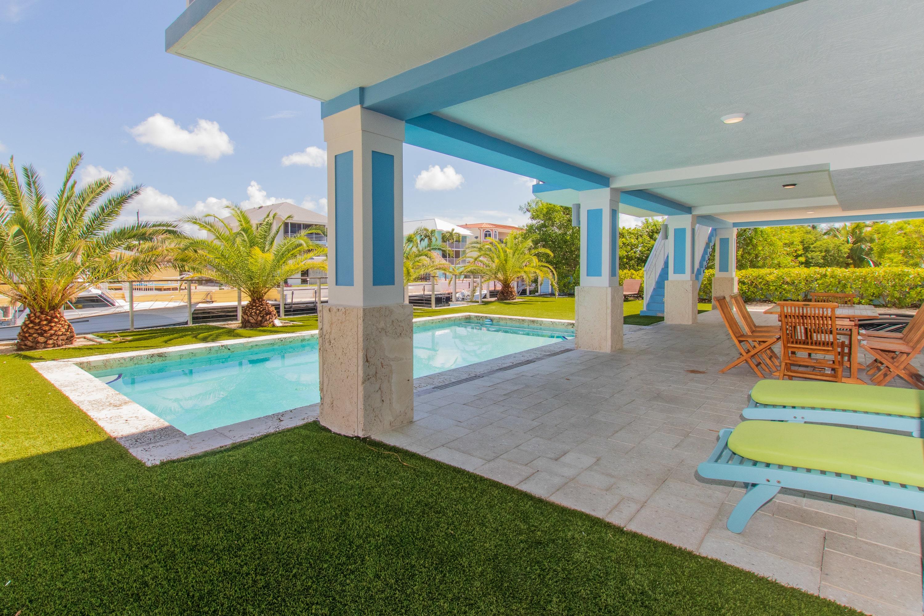 View of in-ground pool in luxury, Florida Keys backyard with canal access