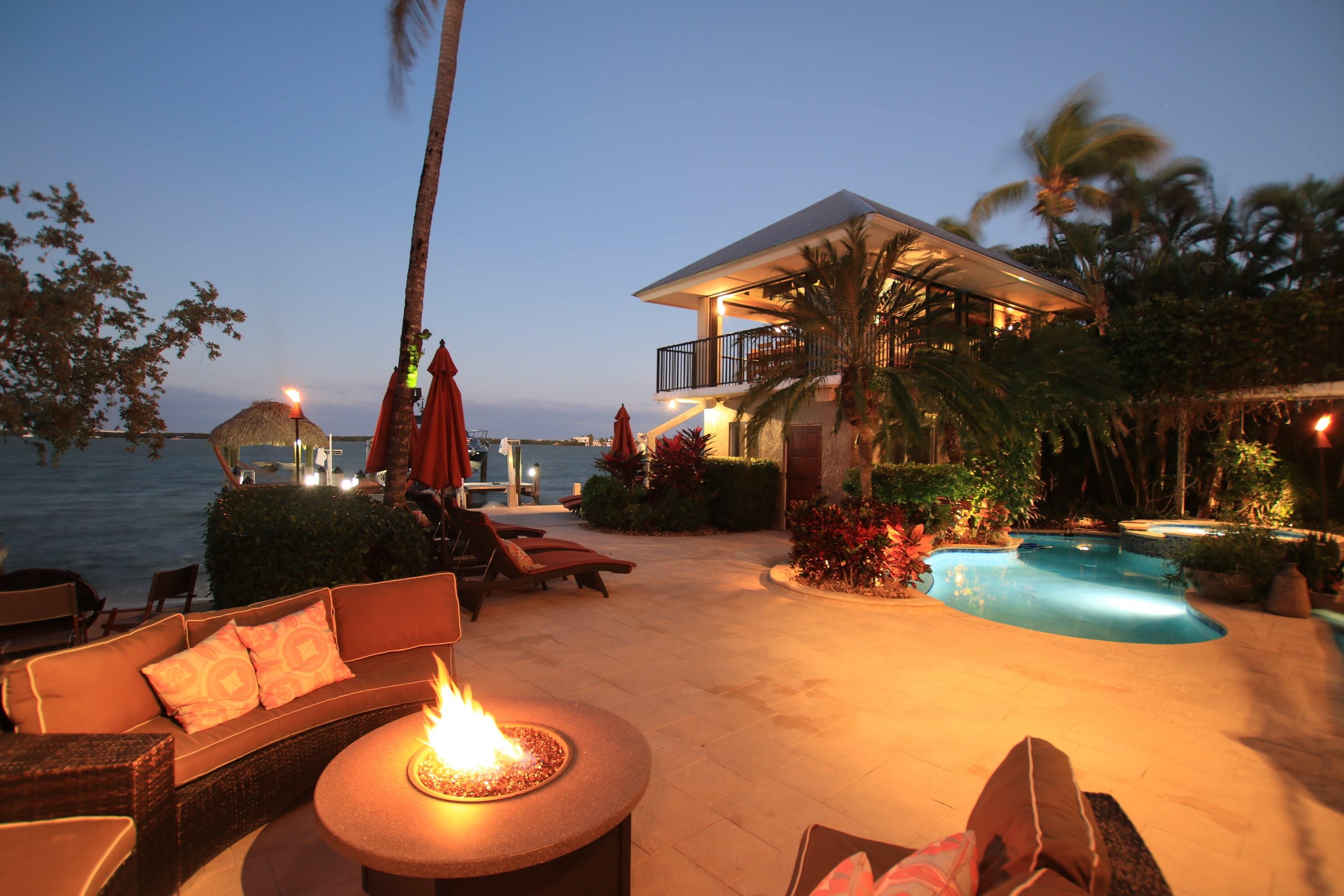 Luxury Florida Keys backyard, with views of the waterfront at nighttime